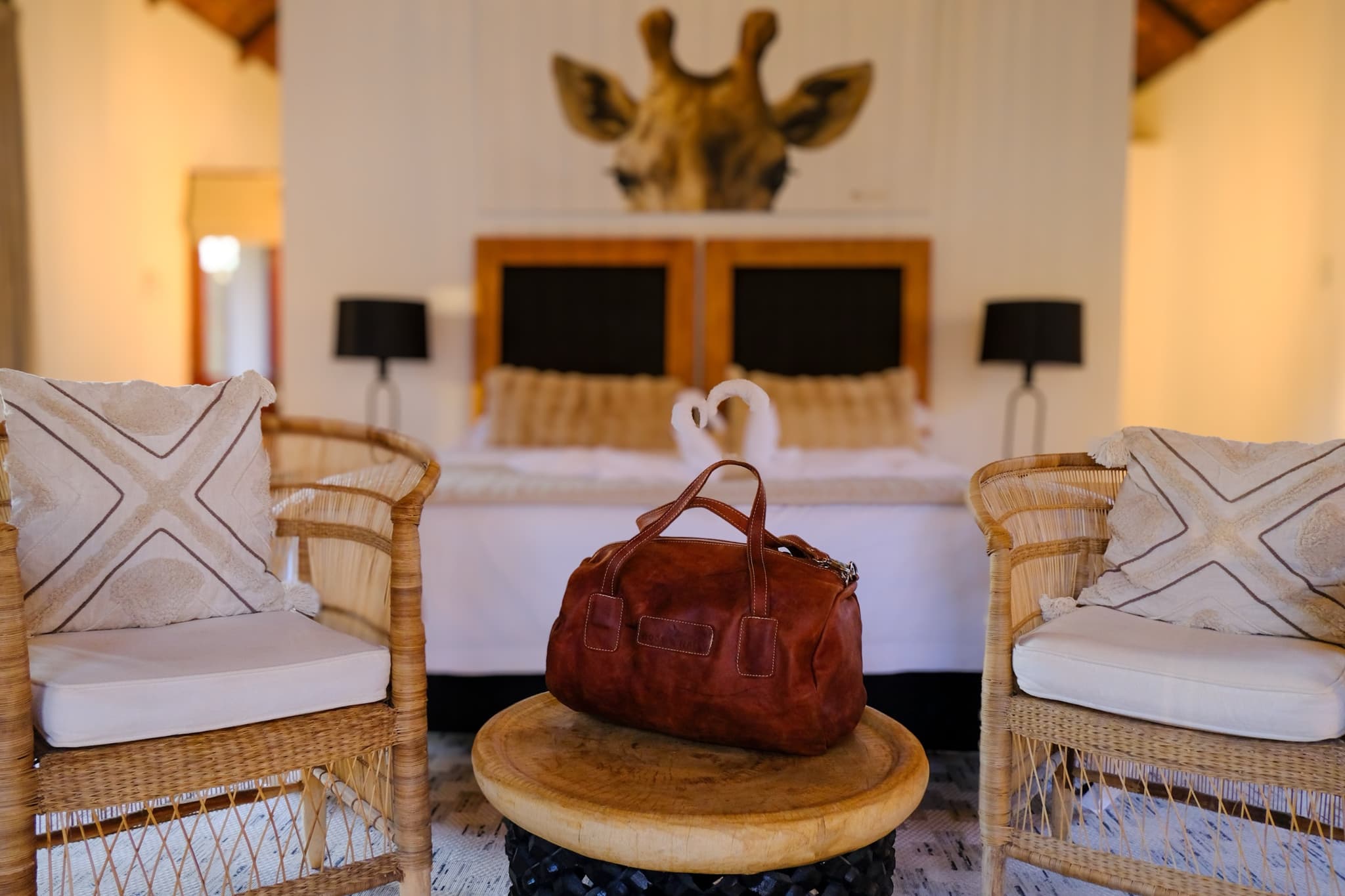 Suite bedroom with giraffe art and leather travel bag