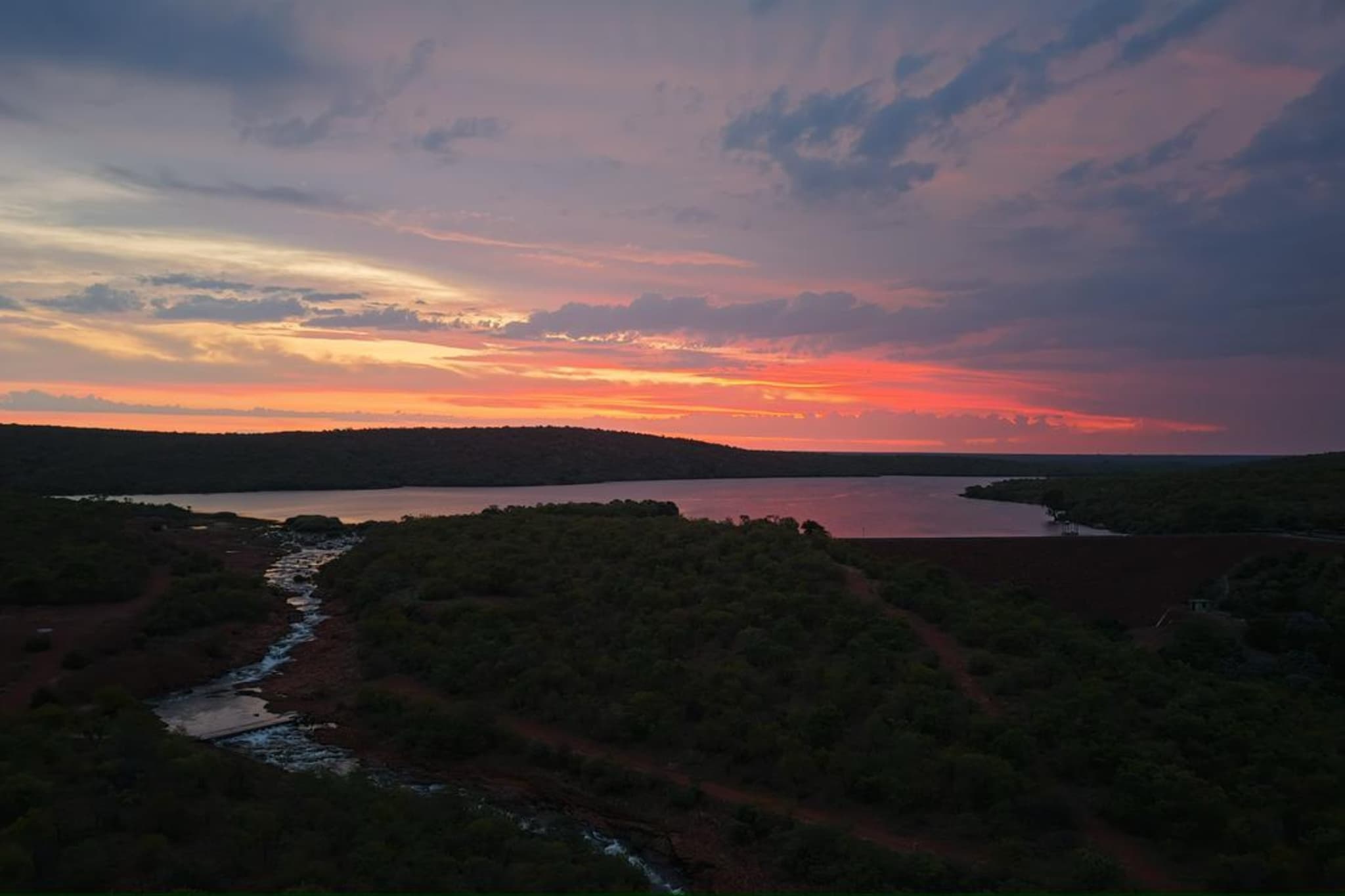 Aerial sunset over the dam with golden reflections