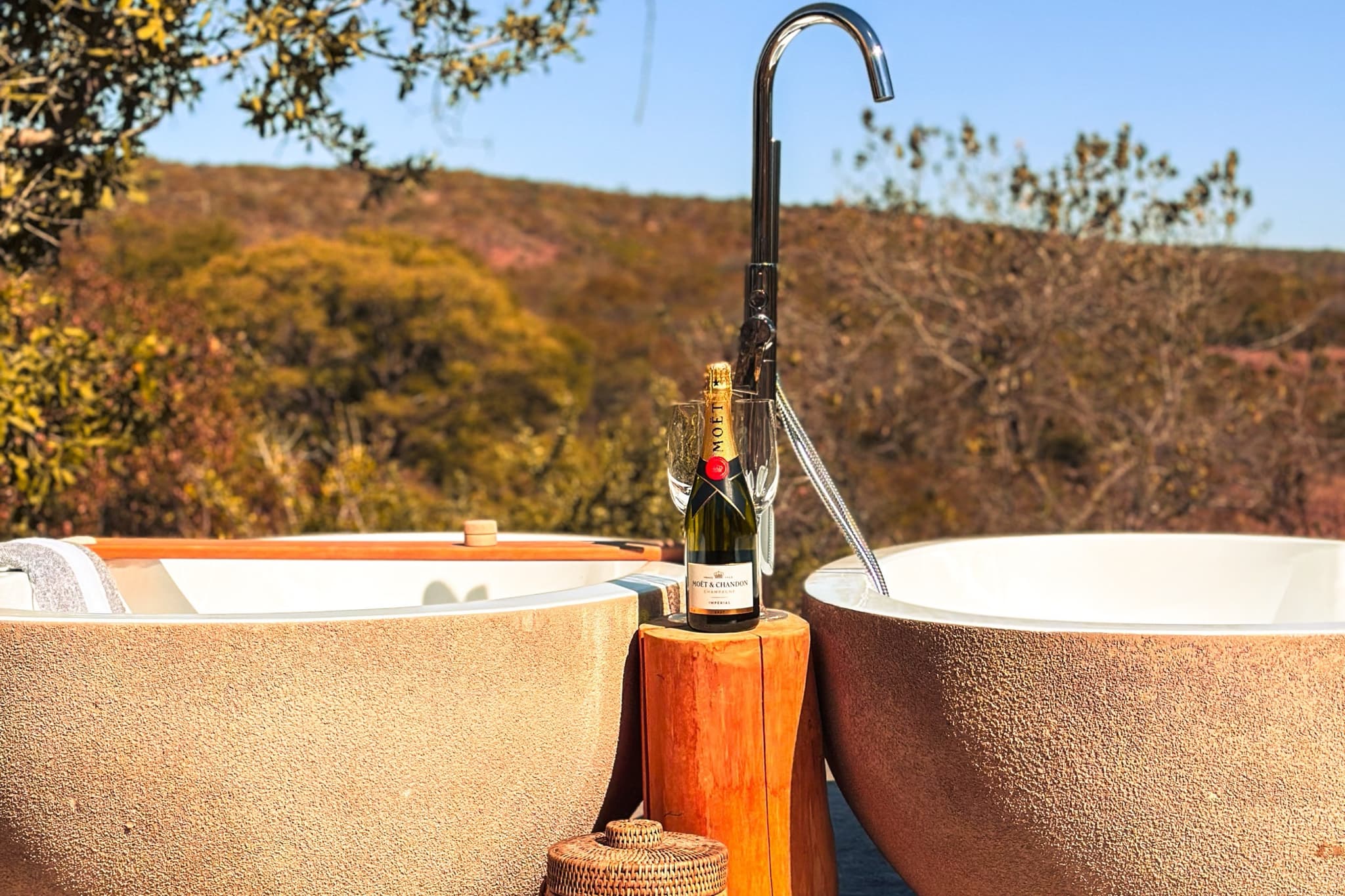 Twin outdoor bathtubs overlooking the bush